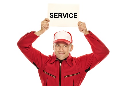Mechanic in red Overall holding a sign with "Service" on it above his head, isolated on whiteの写真素材