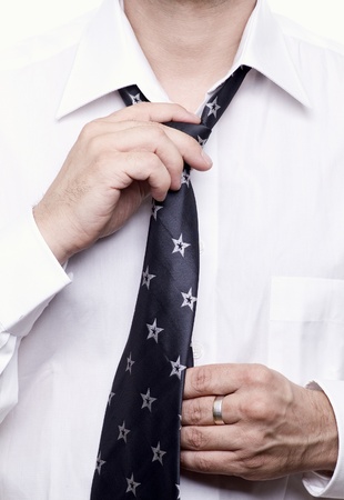 Business man getting ready for work, fixing his tieの写真素材