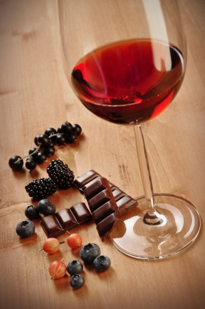 Glass of red wine with fruits and chocolate, isolated on whiteの写真素材