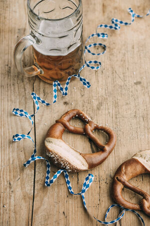 Oktoberfest: Masskrug of beer, Pretzels and bavarian streamer on rustic wooden tableの写真素材