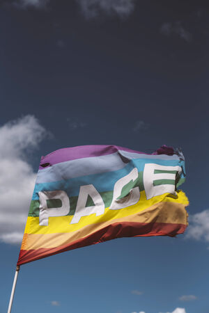 Pace, Peace Flag waving against blue sky with some nice white cloudsの写真素材