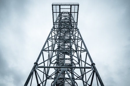 a steel telecommunication tower with a cloudy sky backgroundの写真素材