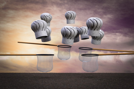Chef hats falling from sky and the nets try to catch them at sunset magenta day demonstrating...