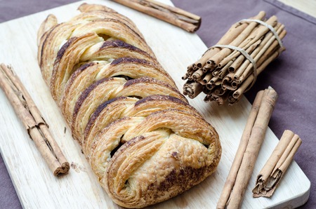 Bun with cinnamon sticks on a cutting board