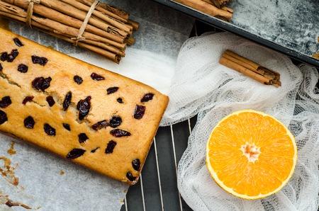Top view of cake with dried berries, cinnamon and orang on the gridの写真素材
