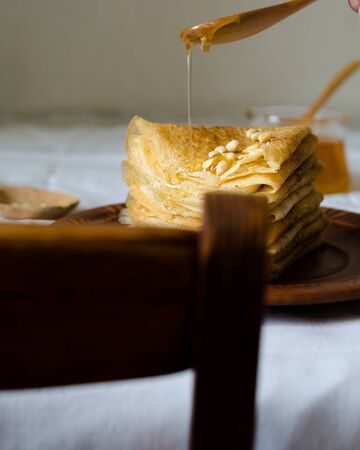 Traditional russian pancakes and crepes with hohey and pine nutsの写真素材