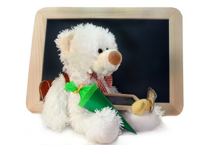 Teddy with a school bag and school cone in front of a blackboardの写真素材
