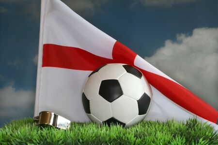 National flag, whistle and a football against a cloudy skyの写真素材