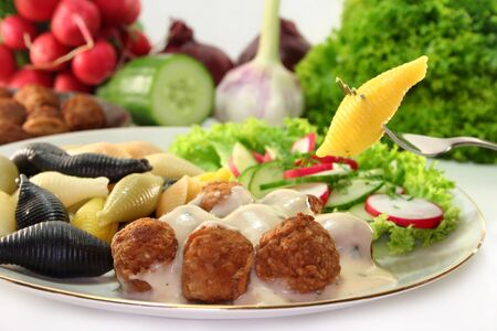 Swedish meatballs with noodles and radish-cucumber saladの写真素材