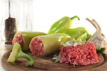 raw, stuffed peppers on a wooden boardの写真素材