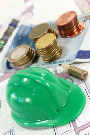 Construction helmet with euros on a housing planの写真素材