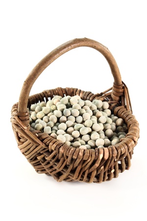 dried green peas in a basket on a white backgroundの写真素材