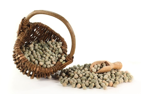 dried green peas in a basket on a white backgroundの写真素材