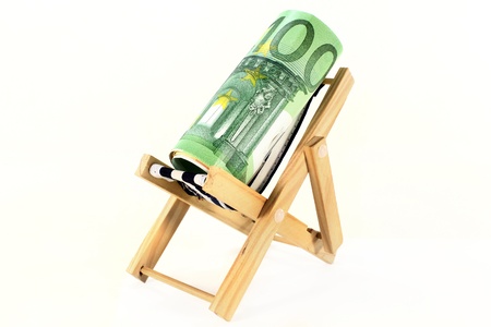 a reclining chair with a roll of euro billsの写真素材