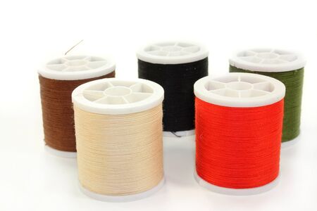 different colored sewing thread on a white background