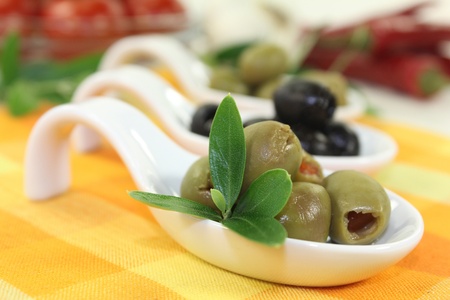 Olives with olive leaves on a spoonの写真素材
