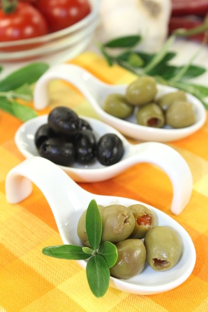 Olives with olive leaves on a spoonの写真素材