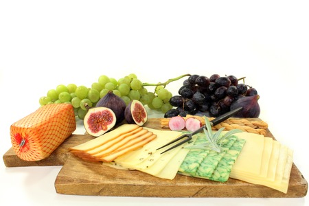 a wooden board with a variety of cheeses