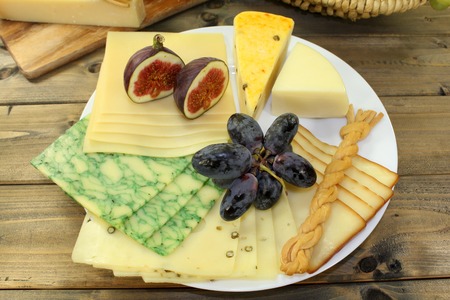 a white plate of various cheesesの写真素材