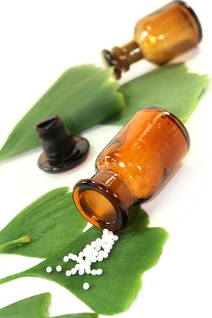 Ginkgo leaves with pharmacists bottle against white backgroundの写真素材