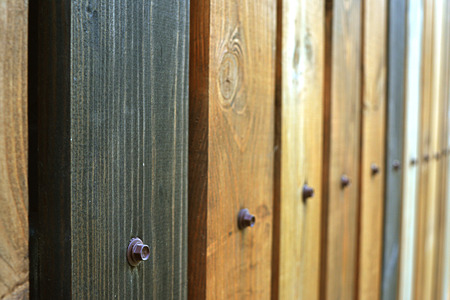 Fence as a background of multicolored wooden boards, with nails vertical texture in perspectiveの写真素材