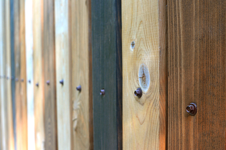 Fence as a background of multicolored wooden boards, with nails vertical texture in perspectiveの写真素材