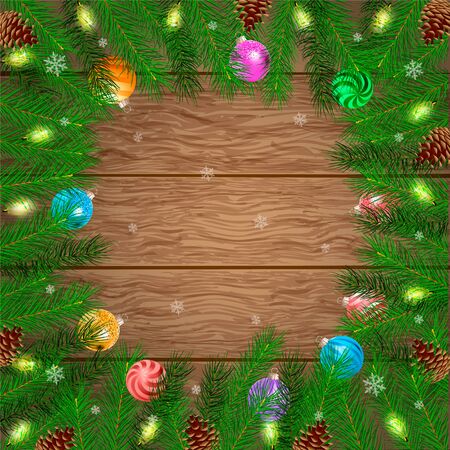 Christmas card. Frame of pine branches, cones and Christmas balls on a wooden board background. Empty space for your text.の写真素材