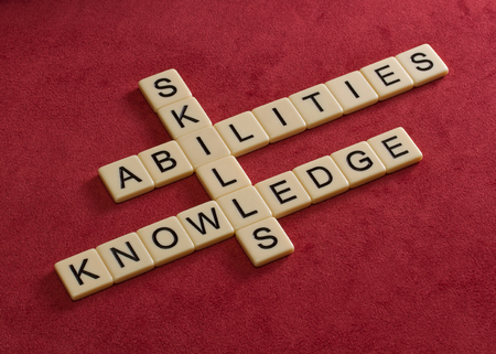 Crossword puzzle with words Skills, abilities, knowledge. Learning concept. Ivory tiles with capital letters on red velure.の写真素材
