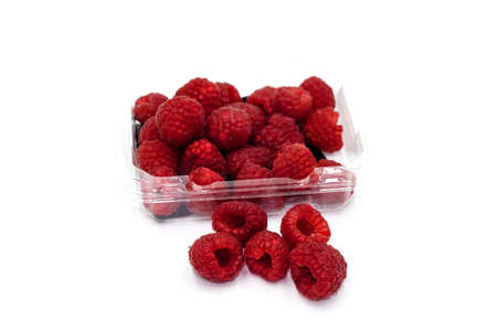 Fresh raspberries in clear plastic box isolated on white background.