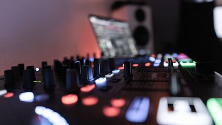 Side View of an illuminated DJ Controller with Laptop and Loudspeakerの写真素材