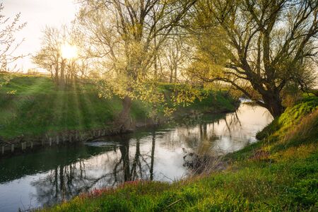Sunset on a river and a reflecting water surfaceの写真素材