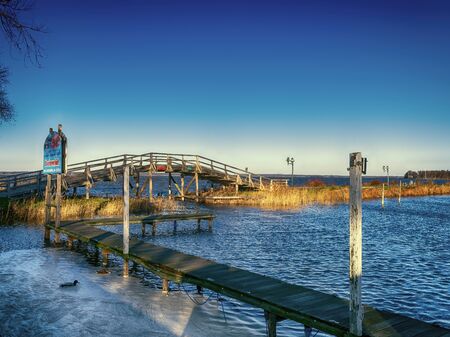 Lake with a small bridge and jetty in the sunの写真素材