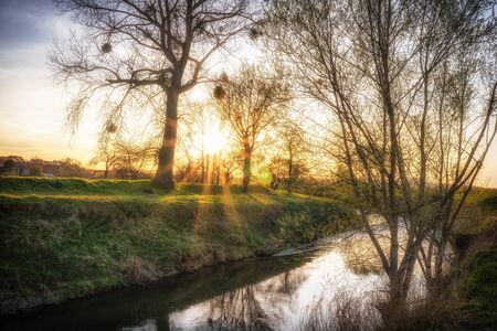 Sunset on a river with a reflecting water surfaceの写真素材