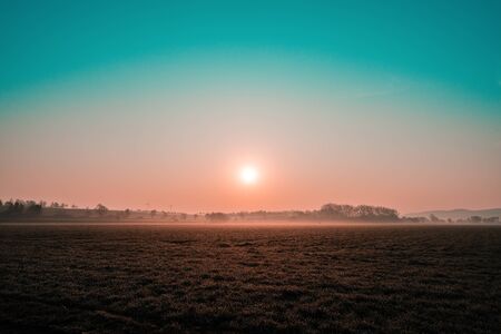 Colorful sunrise on a wide field viewの写真素材