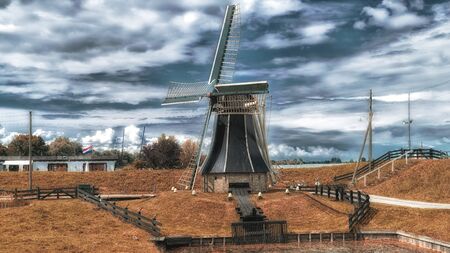 Dutch windmill in a landscape with cloudsの写真素材
