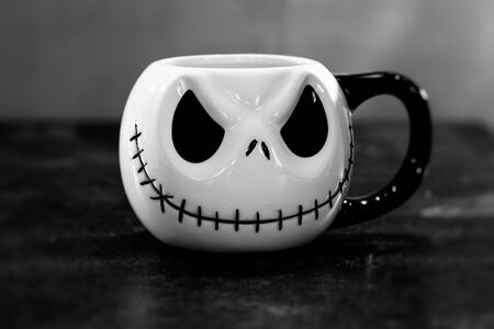A Halloween face with a sewn-on mouth on a drinking cup, black and whiteの写真素材