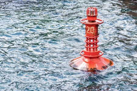 A red metal buoy on the seaの写真素材