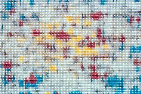 Macro shot of fine white fabric with bright yellow, blue and red blobsの写真素材