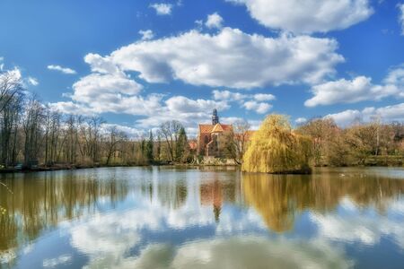 An old monastery in an idyllic atmosphere on a lake in sunshineの写真素材