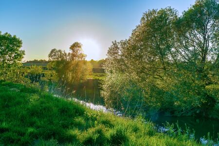 An idyllic evening landscape on a small riverの写真素材