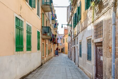 An alley between apartment buildings in the city of veniceの写真素材