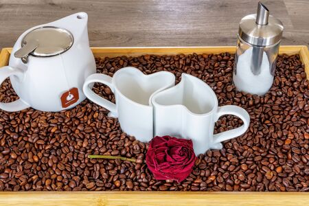 An arrangement of heart cups on a tray with coffee beansの写真素材