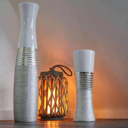 Modern vases in the living area, illuminated by a cozy wooden lampの写真素材