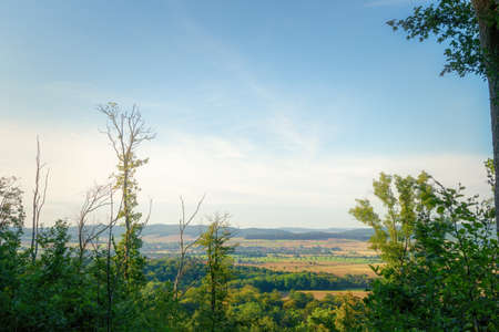 Wonderful view high up from the mountain between the trees of many small villages and fieldsの写真素材