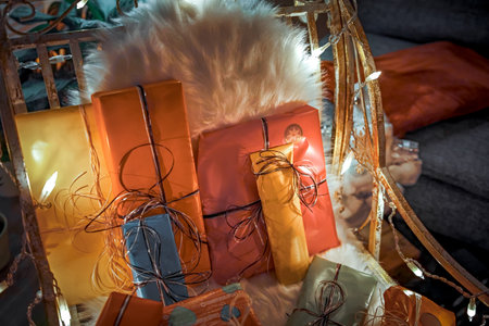 A Christmas lighted chair with gifts and a furの写真素材