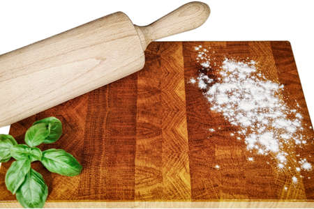 A kitchen wooden board dusted with a little flour, a kitchen roll and fresh basil. Studio shotの写真素材