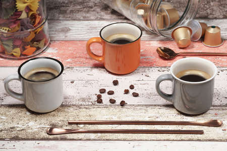 Three colorful cappuccino cups stand on a decorating tableの写真素材
