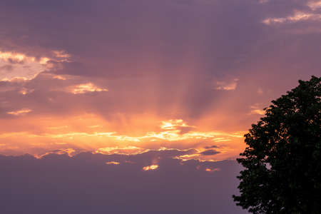 Moody orange sunset between the clouds sky