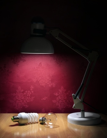 Ecologic light bulbs sitting on table and illuminated by lampの写真素材