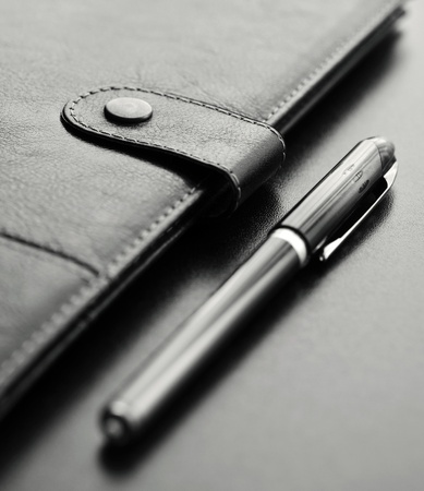 Close-up of a black personal agenda and with a pen with selective focusの写真素材